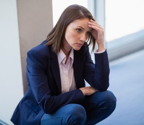 worried-businesswoman-crouching-floor